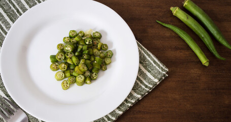 okra prepared on the plate and three raw okra