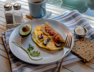Top View of mushroom and cheese omelette on white natural wood table