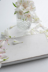Wooden plate with a place for your texts and delicate white flowers on a light background.