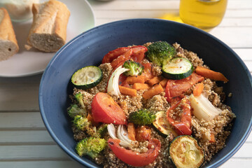 Top view of quinoa salad on white natural wood surface