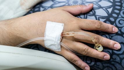 The hand of a female patient who is infused with saline in the hospital