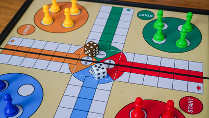 Ludo board game with two dice and four players in red, blue, yellow and green