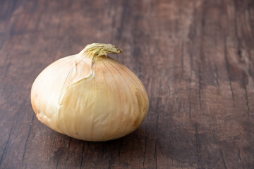 Fresh whole sweet onion on a wood background with room for copy

