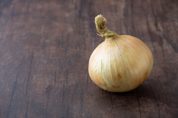 Fresh whole sweet onion on a wood background with room for copy
