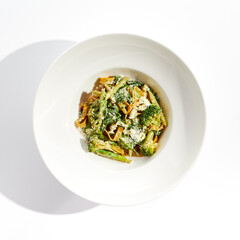 Veggie pasta with broccoli isolated on white background. Vegetarian dish - udon noodle with green...