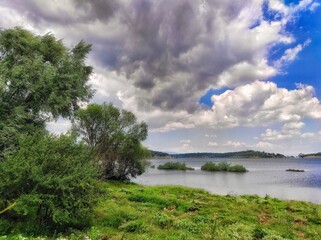 Fototapeta na wymiar Trees, lake and clouds