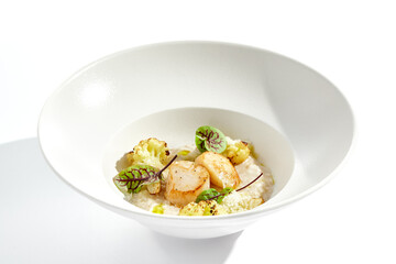 Delicious creamy risotto with sea scallop and cauliflower. Elegant main course with seafood on...
