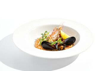 Italian dish - seafood risotto on white plate. Risotto frutti di mare with shrimp, mussels and squid. Seafood in marinara sauce with arborio rice. Paella with prawn and mussels. Seafood menu.
