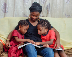 Lovely African Nigerian family consisting of a mother or guardian and two little girl child,...