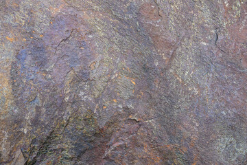Rough cut rock in dark colors of gray and purple, as a natural  background
