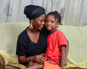 Lovely African Nigerian family consisting of a mother or guardian and her little girl child,...