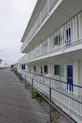View of a three story motel next to a New Jersey beach boardwalk