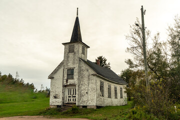 Abandoned, ruin, shamble, broken foundation church building with a spire and a rickety stairway. Prince Edward Island, Canada
