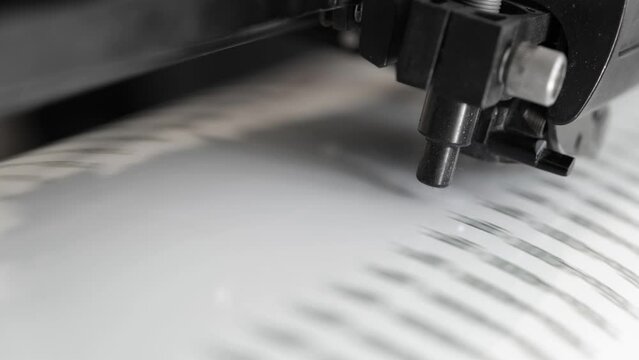Vinyl cutter plotter machine and moving cutting head. Plotter with optical reader. Close-up of print-cut plotter head. Sticker production.