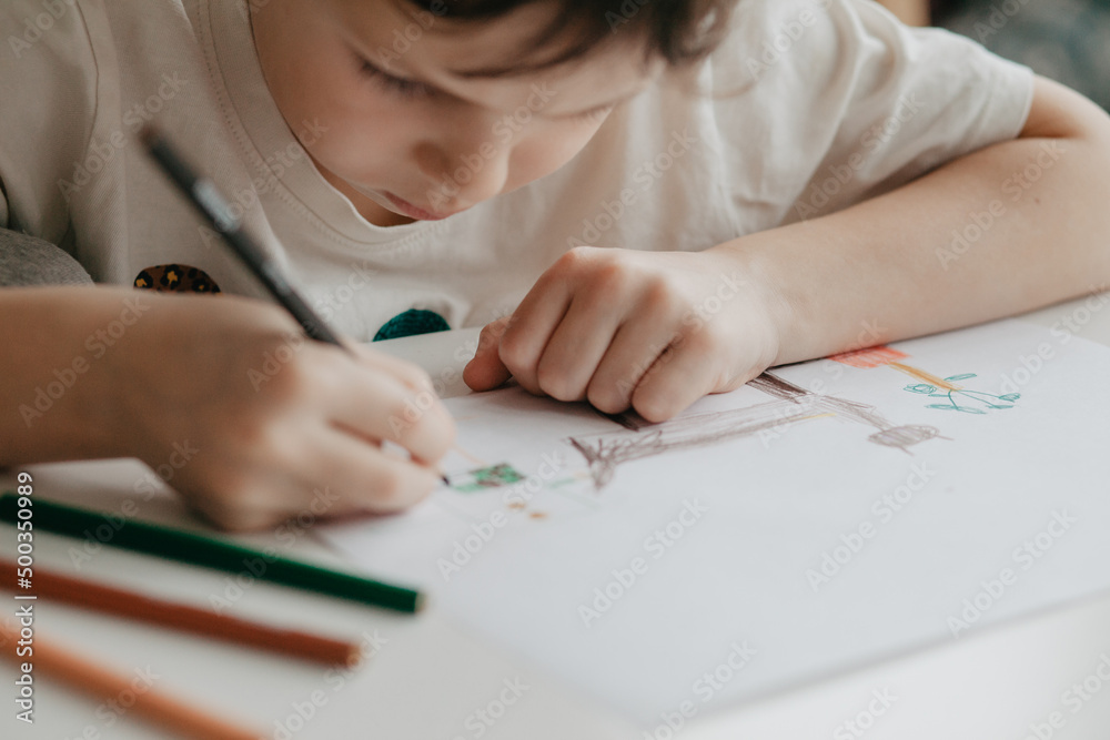 Wall mural The boy draws with pencils at the kitchen