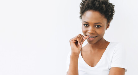 Portrait of charming smiling beautiful young African American woman in white t-shirt isolated on the white background, banner