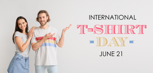 Young couple in stylish t-shirts on light background. International T-shirt Day