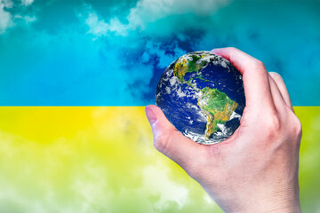 Hand holding globe with smoke on blue and yellow background, Ukraine flag. Help the world to free from the war by supporting Ukrainian, against crime concept. Elements of this image furnished by NASA.