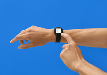 Male hands with modern smart wrist watch on color background