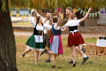 Drunk people dancing and celebrating Octoberfest outdoors