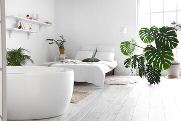Fototapeta na wymiar Stylish interior of bedroom with bathtub