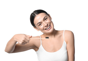 Beautiful woman with dental braces and toothbrush on white background