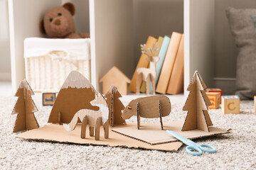 Different handmade cardboard toys on floor in children's room