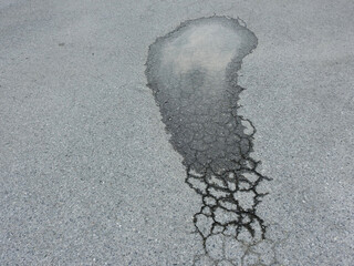 water in the pit on a cracked road after the rain