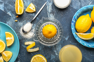 Composition with ripe lemons, juicer and sugar on color background