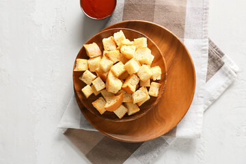 Bowls with tasty croutons, sauce and napkin on white background