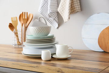 Beautiful dinnerware on kitchen counter near light wall