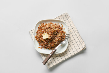 Plate of tasty buckwheat porridge on white background, top view