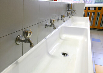 Fototapeta premium nursery bathroom interior with low white ceramic sinks and taps