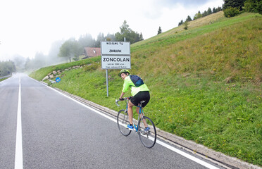 cyclist riding his racing bike on Monte Zoncolan in northern Italy on a very foggy day