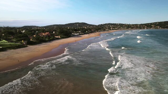 Aerial view of waves rolling into golden sand Geriba Beach in Buzios Brasil