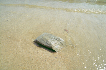 Full sand in plastic bag on the sea.