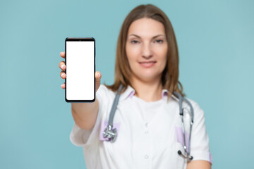 Woman doctor with a smartphone, on a blue background. Place for advertising. Copy paste. healthcare concept.