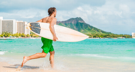 Hawaii surfing lifestyle young man sufer going to surf in blue ocean water in Honolulu, with...