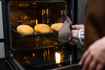 Close-up. The cook prepares bread in an electric oven.
