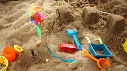 Fototapeta na wymiar Pile of sand and beach toys, Plastic shovel, beach toy for kids in sand pile.