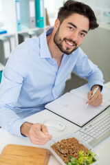 funny surprised office employee eating food while working