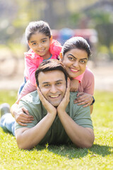 Naklejka na ściany i meble Portrait of happy Indian family spending leisure time at park