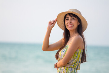Woman wearing a straw hat and smiling. Portrait of a happy young woman with hat looking at camera with copy space.