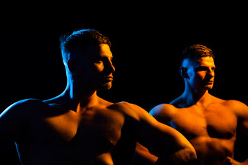 Fitness models and young bodybuilders. Posing chest. Concept of power and healthcare, black background.
