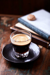 Coffee in glass cup on rustic wooden background