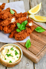 
 Crispy  deep Fried   Chicken strips and wedges potato. Breaded  with cornflakes chicken  Breast Fillets  with chilly peppers and fresh   basil on wooden rustic background