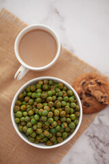 Close-Up of crunchy Indian mixture snacks with hot tea or Coffee time and handmade cookies (biscuits).