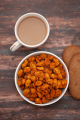 Close-Up of crunchy Indian mixture snacks with hot tea or Coffee time and handmade cookies (biscuits).