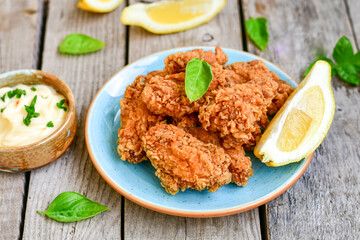 
 Crispy  deep Fried   Chicken strips and wedges potato. Breaded  with cornflakes chicken  Breast Fillets  with chilly peppers and fresh   basil on wooden rustic background