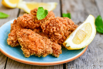 
 Crispy  deep Fried   Chicken strips and wedges potato. Breaded  with cornflakes chicken  Breast Fillets  with chilly peppers and fresh   basil on wooden rustic background